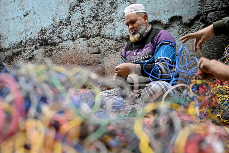 Un homme récupérant le cuivre provenant de déchets de fils électriques dans un site informel de recyclage de déchets électroniques à Seelampur, New Delhi, le 28 janvier 2026