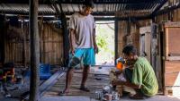 Le noble Umbu Ana Rara (g) regarde son esclave (d) Kanisius Kanyali Hambarita préparer des boissons au village de Tanggedu, dans l'est de l'île de Sumba, le 23 juin 2026 en Indonésie
