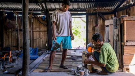 Le noble Umbu Ana Rara (g) regarde son esclave (d) Kanisius Kanyali Hambarita préparer des boissons au village de Tanggedu, dans l'est de l'île de Sumba, le 23 juin 2026 en Indonésie