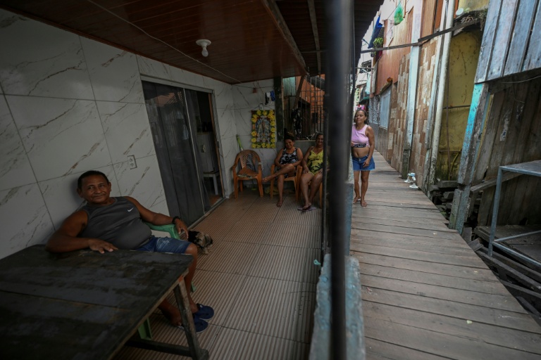 Des habitants de Vila da Barca, un quartier pauvre bâti sur pilotis sur les rives du fleuve Guama à Belem, dans l'État du Para, le 5 novembre 2025 au Brésil