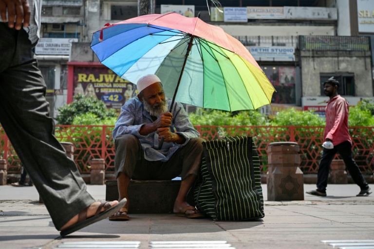 Un homme se protège du soleil pendant une vague de chaleur en Inde le 13 mai 2026