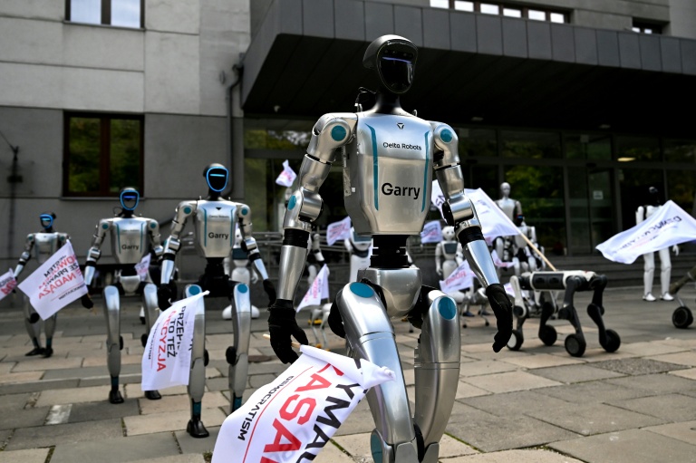 Munis de drapeaux, des robots manifestent devant le ministère polonais du Numérique, à Varsovie, pour demander l'encadrement de l'intelligence artificielle (IA) dans le monde du travail, le 7 septembre 2026