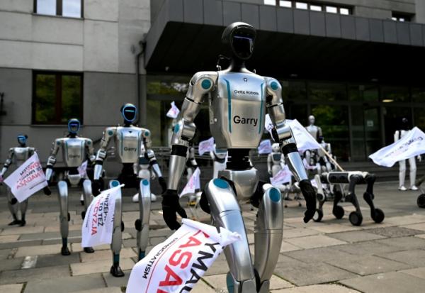 Munis de drapeaux, des robots manifestent devant le ministère polonais du Numérique, à Varsovie, pour demander l'encadrement de l'intelligence artificielle (IA) dans le monde du travail, le 7 septembre 2026