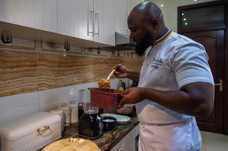 Le chef congolais Archi Dimosi surveille la cuisson d'une sauce dans sa cuisine à Kinshasa, le 17 mai 2026 en RDC