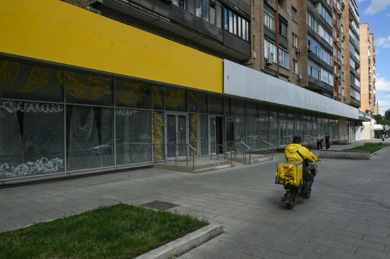 Un livreur passe devant la façade d'une enseigne fermée, à Moscou, le 28 juin 2026