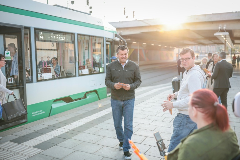 Sven Schulze (au centre), ministre-président de Saxe-Anhalt et candidat tête de liste du parti conservateur CDU aux élections régionales, parle avec un passant près de la gare centrale de Magdebourg, dans l'est de l'Allemagne, le 27 août 2026