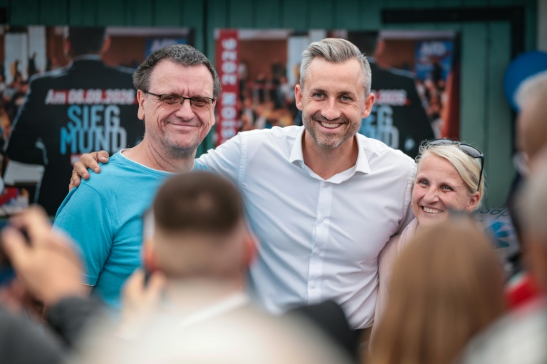 Ulrich Siegmund (C), candidat du parti d'extrême droite AfD aux élections régionales de Saxe-Anhalt, pose pour des photos avec des sympathisants lors d'un meting électoral à Haldensleben, dans l'est de l'Allemagne, le 1er septembre 2026