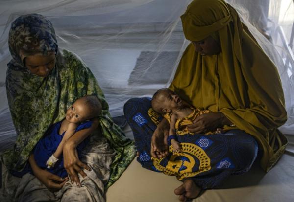 Des femmes somaliennes récemment déplacées tiennent dans leurs bras leurs bébés souffrant de malnutrition sévère dans un centre de santé, à Kismayo, le 22 avril 2026 