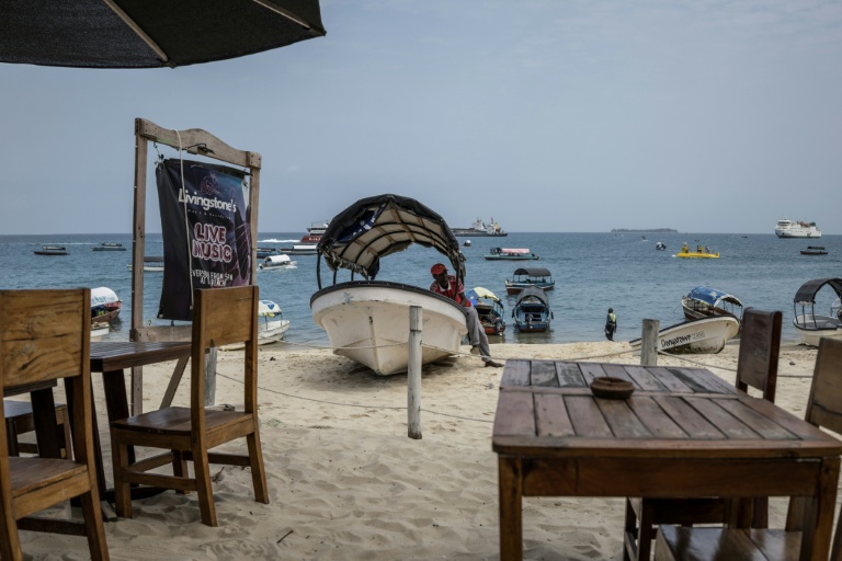 Un commerçant attend les touristes sur son bateau sur la plage de Stone Town, en Tanzanie, le 24 octobre 2025