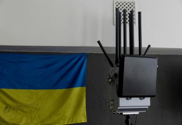 Un brouilleur antidrone à côté d'un drapeau ukrainien, dans une entreprise de fabrication de brouilleurs, à Kiev le 7 mai 2026, en Ukraine