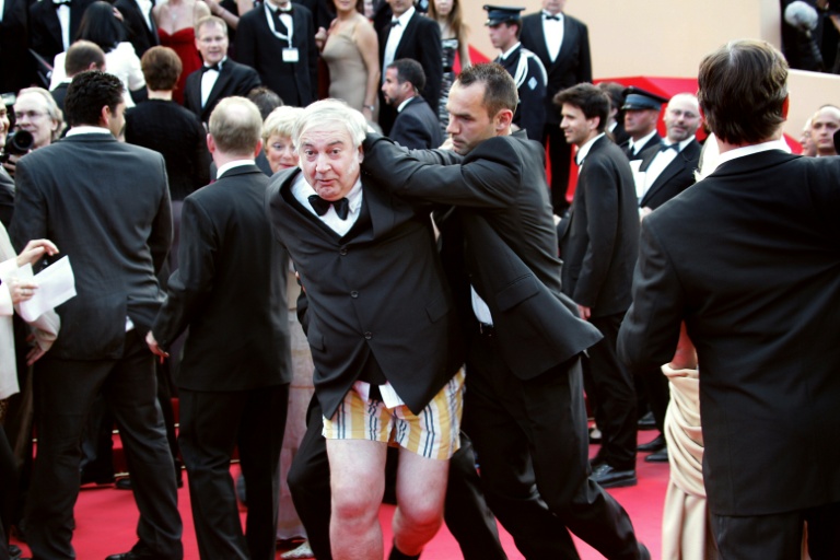 Le comique et entarteur belge Noël Godin est évacué du tapis rouge du Palais des Festivals par le service de sécurité, le 15 mai 2004, juste avant l'arrivée des célébrités pour la projection officielle de 