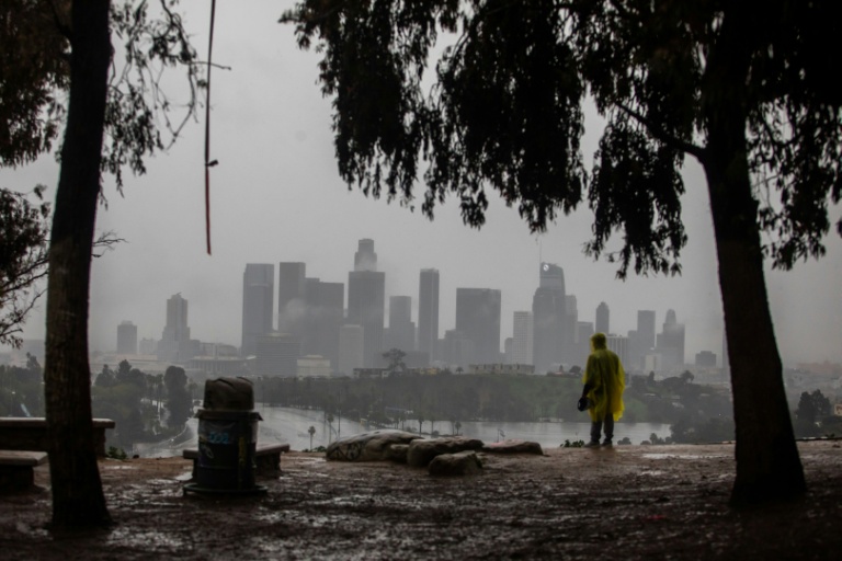 Un homme vêtu d'une cape imperméable regarde la pluie tomber sur Los Angeles, en Californie, le 24 décembre 2025