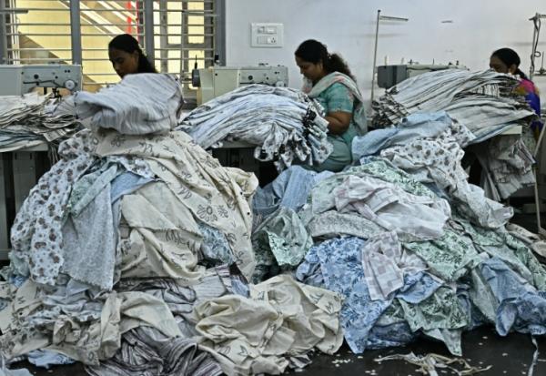 Des ouvrières confectionnent des vêtements sur des machines à coudre dans une usine de fabrication à Bengaluru, en Inde, le 25 août 2025 