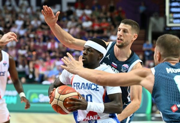 Inarrêtable, le meneur de jeu de l'équipe de France Sylvain Francisco résiste aux  Slovènes Edo Muric et Gregor Hrovat dans le groupe D de l'Euro à Katowice, le 30 août 2025 