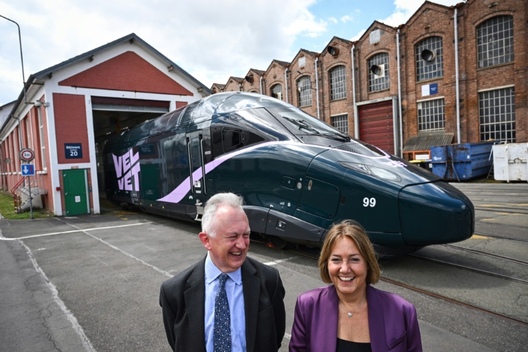 Rachel Picard (D) et Timothy Jackson, cofondateurs de la compagnie ferroviaire privée française Velvet, posent devant l'une des locomotives de leur entreprise à l'usine Alstom de Belfort, dans l'est de la France, le 27 juin 2025