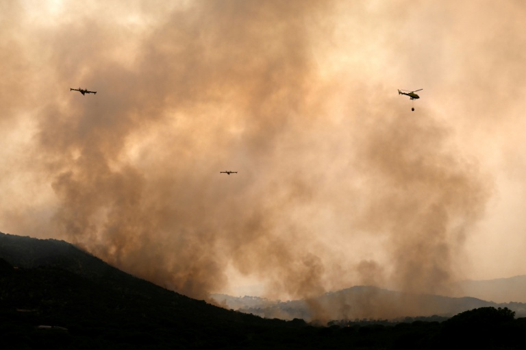 Des avions de lutte contre les incendies larguent de l'eau sur un feu de forêt près du village de Cebreros, dans la province d'Ávila, en Espagne, le 27 juillet 2026