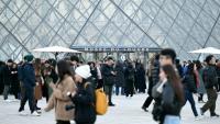 Des visiteurs devant la pyramide du Louvre le 15 décembre 2025 à Paris