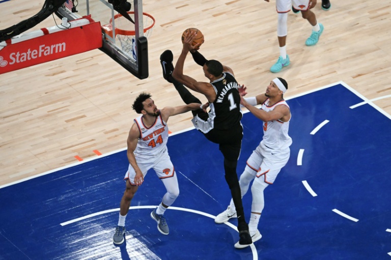 Le basketteur français des San Antonio Spurs Victor Wembanyama tire au panier sous la défense de Landry Shamet et de Josh Hart des New York Knicks, lors du troisième match de la finale de la NBA au Madison Square Garden de New York, le 8 juin 2026