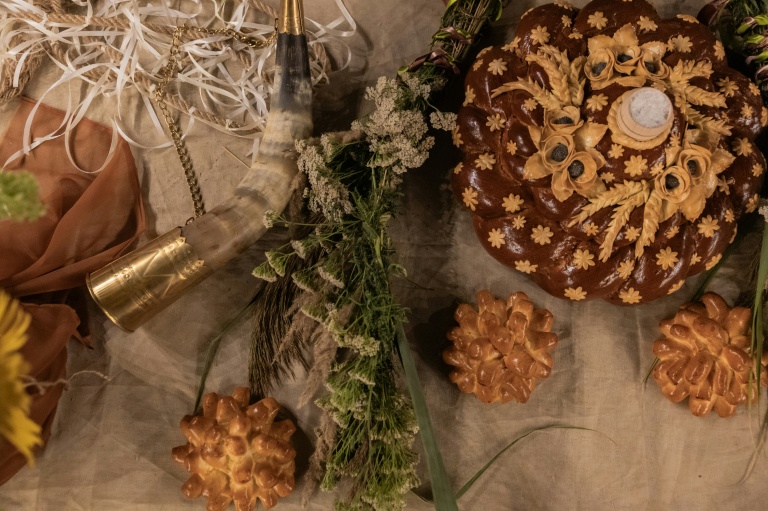 Un korovaï, pain rond cérémoniel accompagné de sel, est disposé avec d'autres objets rituels sur une table lors d'une 