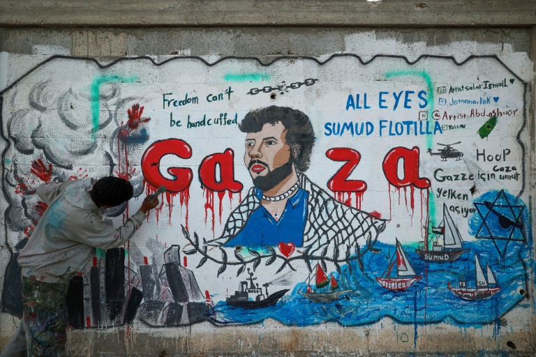 Un artiste peint une fresque dénonçant l'interception par Israël de la flottille pour Gaza, le 19 mai 2026 à Nousseirat, dans le centre de la Bande de Gaza