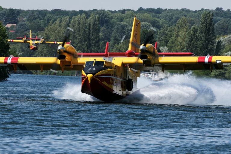 Un Canadair CL-415 de la Sécurité civile effectue des manœuvres d'écopage au-dessus de la Seine à Chartrettes, pour lutter contre un incendie dans la forêt de Fontainebleau, le 13 juillet 2026 en Seine-et-Marne