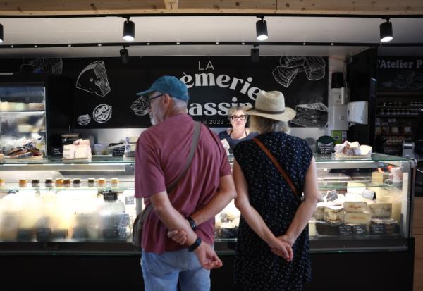 Des clients se font servir chez un fromager au marché d'Andernos-les-Bains, en Gironde, le 1er août 2026