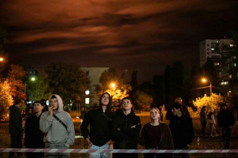 Des habitants observent le site d'une frappe ruasse sur un immeuble résidentiel à Kiev, le 14 octobre 2026 en Ukraine