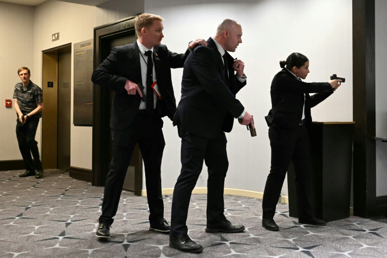 Des agents sont arme au poing après que des détonations ont été entendues au dîner des correspondants de la Maison Blanche, à l'hôtel Washington Hilton, le 25 avril 2026 à Washington