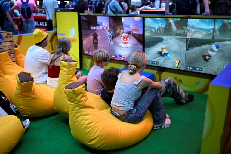 Des participants jouent à des jeux vidéos au salon Gamescom, le 21 août 2025 à Cologne, en Allemagne