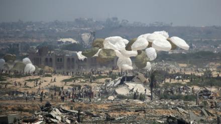Des palettes d'aide humanitaire sont larguées par un avion militaire au-dessus de Nousseirat, dans le centre de la bande de Gaza, le 18 août 2025
