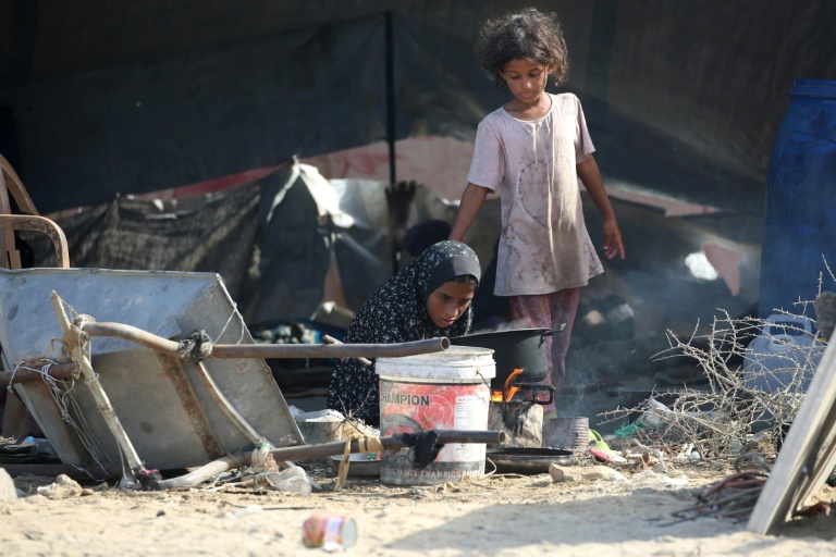 Des jeunes Palestiniennes déplacées devant une tente installée au nord-ouest du camp de réfugiés de Nousseirat, dans le centre de la bande de Gaza assiégée, le 4 octobre 2025