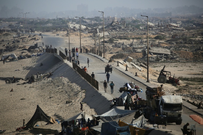 Des Palestiniens marchent sur un sentier côtier au nord-ouest du camp de réfugiés de Nousseirat, dans la bande de Gaza assiégée, le 4 octobre 2025