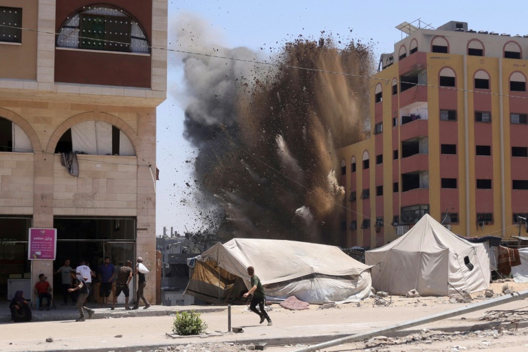 Des Palestiniens se précipitent pour se mettre à l'abri après qu'une frappe israélienne a touché un immeuble à Jabalia, dans le nord de la bande de Gaza, le 20 août 2025