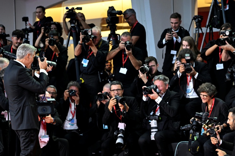 L'acteur et réalisateur américain George Clooney prend une photo de la photojournaliste Tiziana Fabi, à Venise le 2 septembre