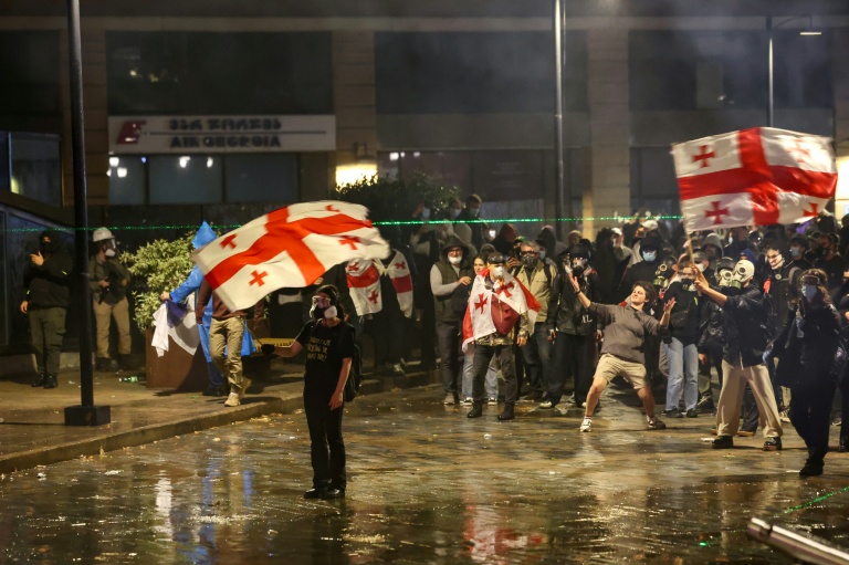 Des manifestants face à la police anti-émeute lors d'un rassemblement de l'opposition le jour des élections locales, le 4 octobre 2025 à Tbilissi, en Géorgie