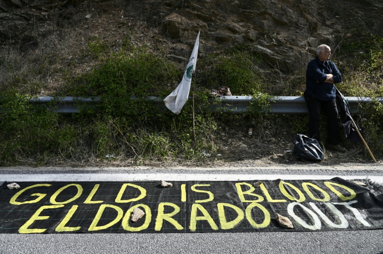 Un manifestantà côté d'une banderole lors d'une manifestation en marge de l'inauguration de la mine d'or et de cuivre de Skouries, dans la péninsule de Chalcidique, dans le nord de la Grèce, le 8 octobre 2026