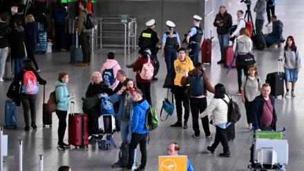 Des passagers attendent près d'un comptoir de la compagnie aérienne à l'aéroport de Francfort, alors qu'une grande partie des vols sont annulés pour cause de grève le 12 mars 2026