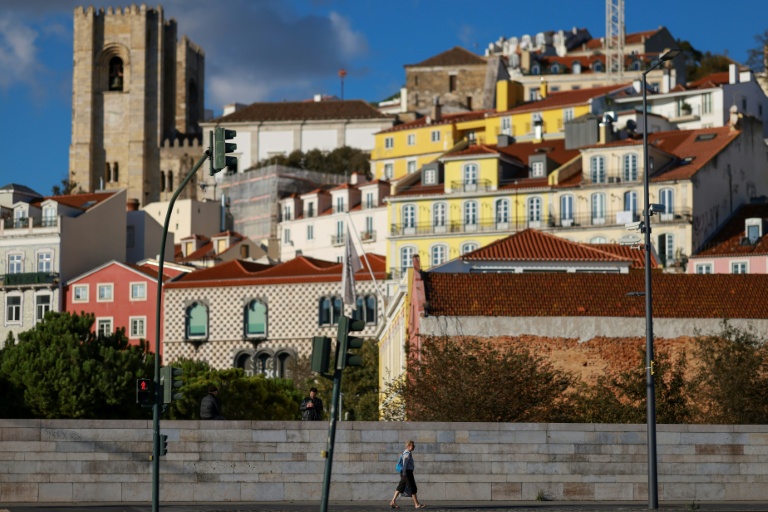 Une femme marche à Campo das Cebolas, un quartier de Lisbonne, le 18 novembre 2025