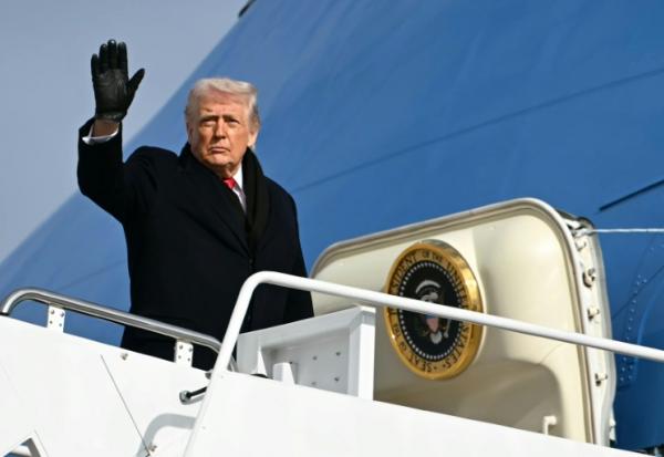 Le président américain Donald Trump fait un signe de main en en montant à bord de l'avion présidentiel le 16 janvier 2026, à la base d'Andrews, dans le Maryland, à l'est des Etats-Unis