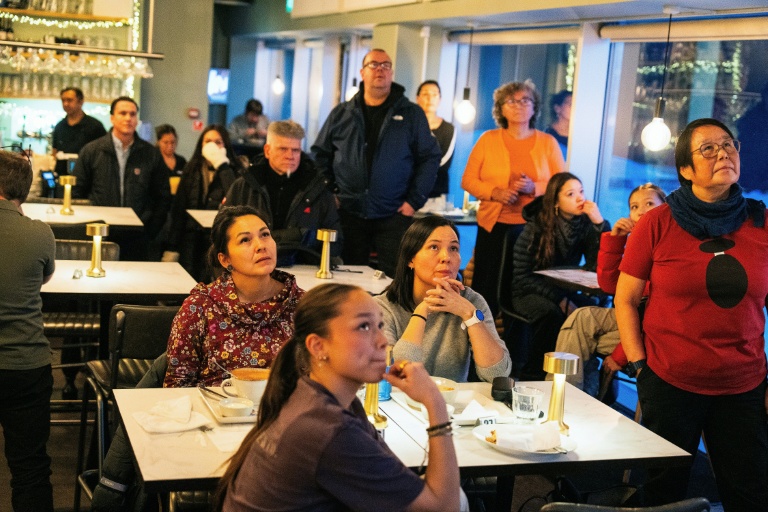 Des habitants de Nuuk, au Groenland, regardent les informations télévisées, le 14 janvier 2026