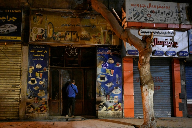 Un commerçant ferme sa boutique dans le centre-ville du Caire en applicaton du couvre-feu, le 2 avril 2026 en Egypte