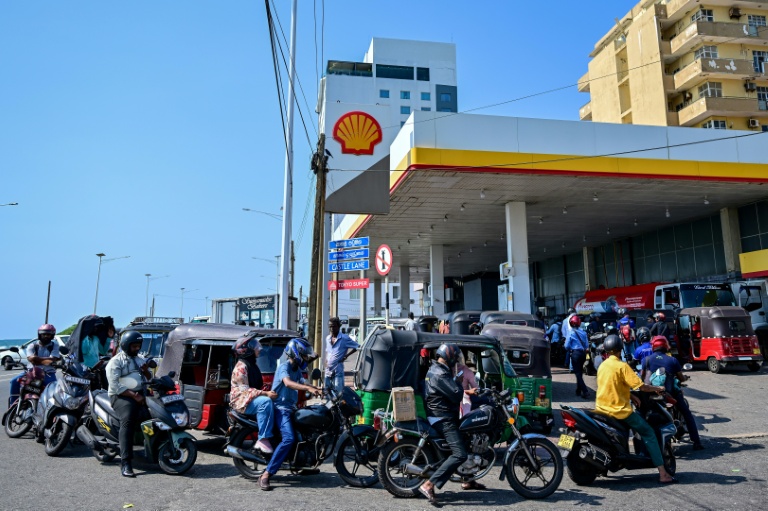 Des motoyclistes font la queue pour prendre du carburant à une station-service de Wellawatte, près de Colombo, le 16 mars 2026 au Sri Lanka 