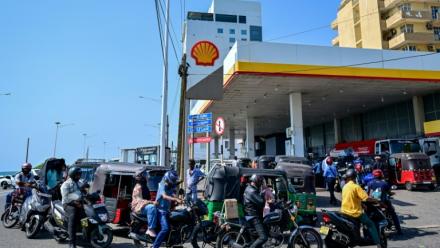 Des motoyclistes font la queue pour prendre du carburant à une station-service de Wellawatte, près de Colombo, le 16 mars 2026 au Sri Lanka 