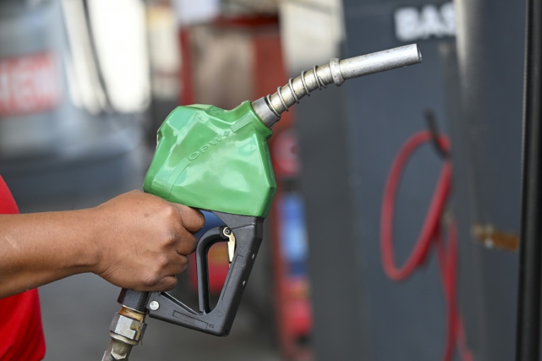 Un automobiliste se sert en carburant dans une station-service à Guatemala City, le 19 mars 202+