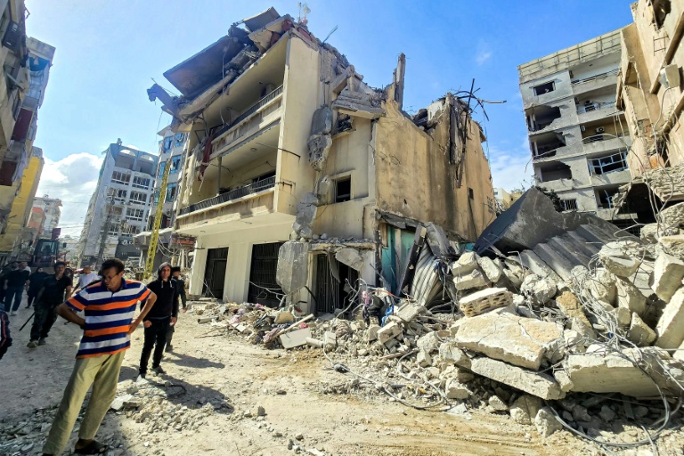 Des habitants devant les décombres de bâtiments endommagés et effondrés après des frappes israéliennes nocturnes sur la ville de Tyr, dans le sud du Liban, le 16 mai 2026