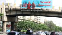 Une affiche anti-américaine sur laquelle est écrit en persan "Nos canons sont pleins" en référence au détroit d'Ormuz, déployée sur un pont au-dessus d'une autoroute à Téhéran, le 12 mai 2026