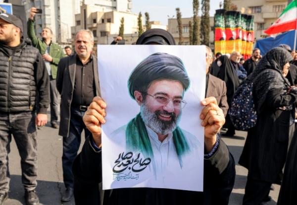 Une femme tient un portrait du nouveau guide suprême iranien, l'ayatollah Mojtaba Khamenei, lors d'un rassemblement de soutien àe Téhéran, le 9 mars 2026 en Iran