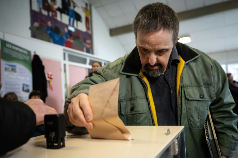 Une personne en situation de handicap intellectuel glisse son bulletin dans l'urne lors d'un faux scrutin organisé le 17 février 2026 à Saint-Dié-des-Vosges