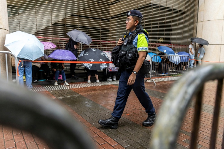 Un policier en patrouille devant la Cour de West Kowloon, à Hong Kong, avant l'arrivée de Jimmy Lai pour son procès, le 18 août 2025