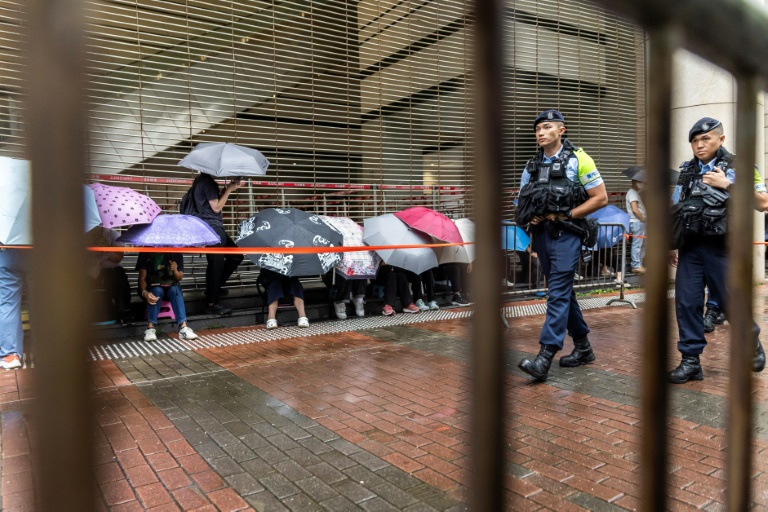Des policiers devant le tribunal de West Kowloon avant l'arrivée du magnat des médias Jimmy Lai pour son procès à Hong Kong, le 18 août 2025